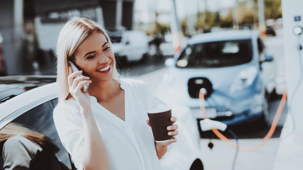 Frau lädt Elektroauto