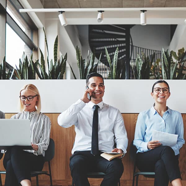 zwei business Frauen und ein Mann sitzen auf Stühlen nebeneinander