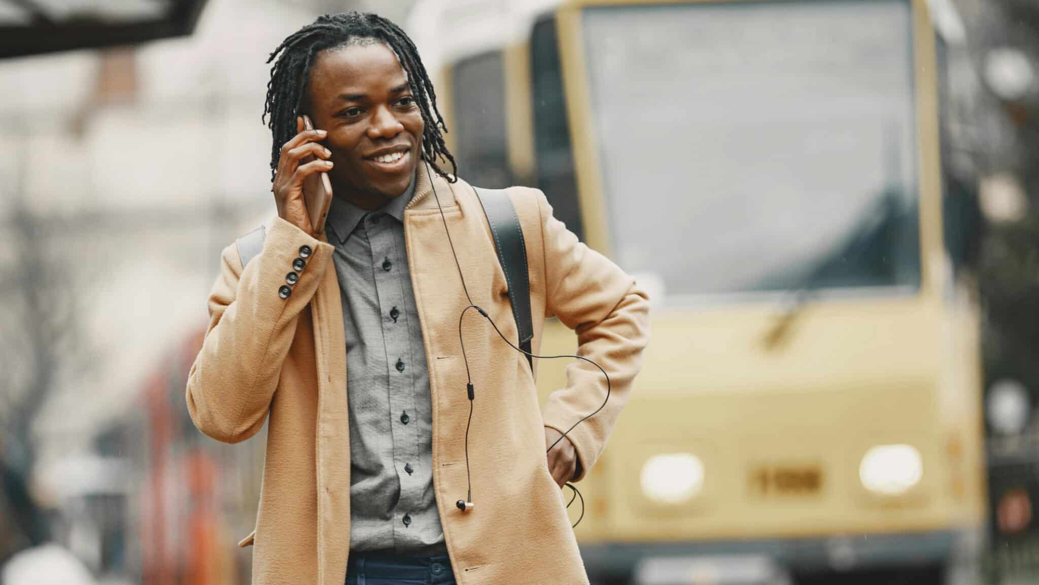 Mann steht vor Tram und telefoniert