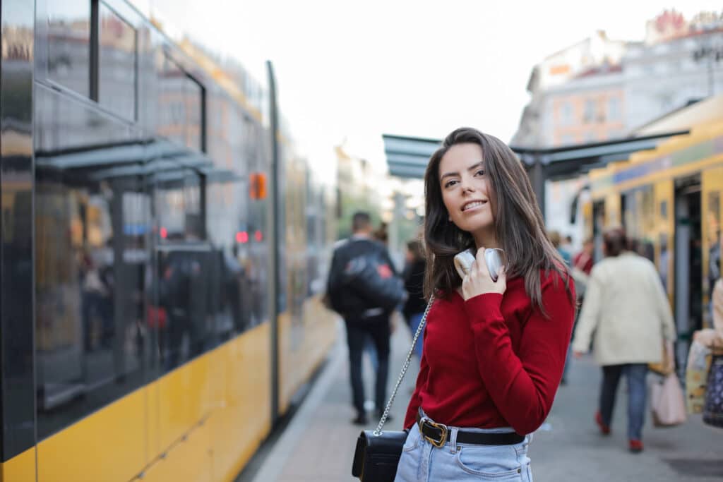 Junge Frau steht am Bahngleis