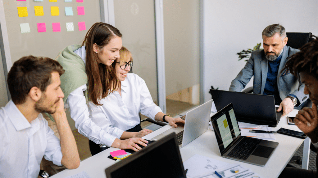 Team arbeitet gemeinsam am Schreibtisch etwas aus